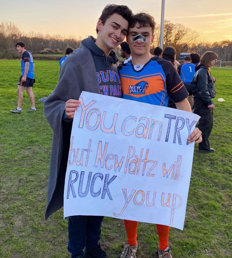 Caleb Persanis with his boyfriend, Daniel. who is holding a sign of support.