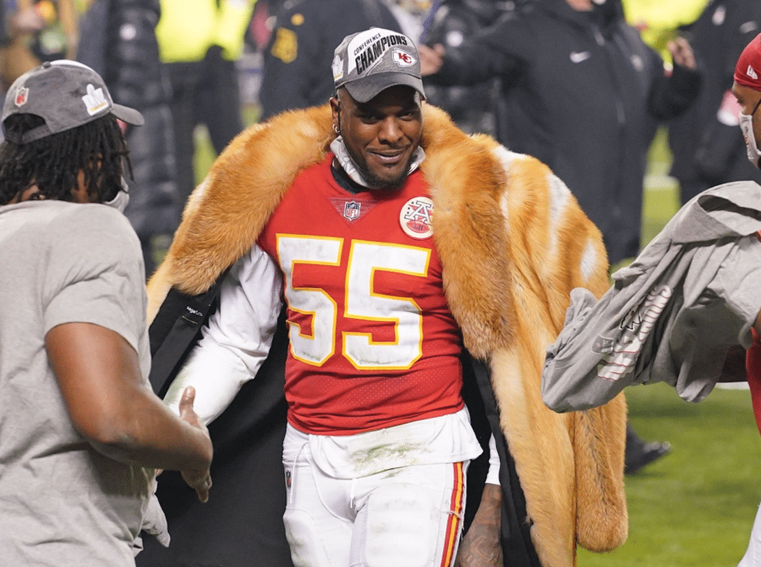 Kansas City Chiefs players on the field with one wearing a fur coat.